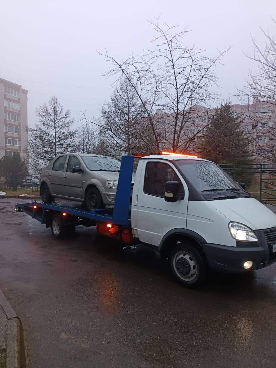 Эвакуатор забирает легковой автомобиль во дворе в Великом Новгороде